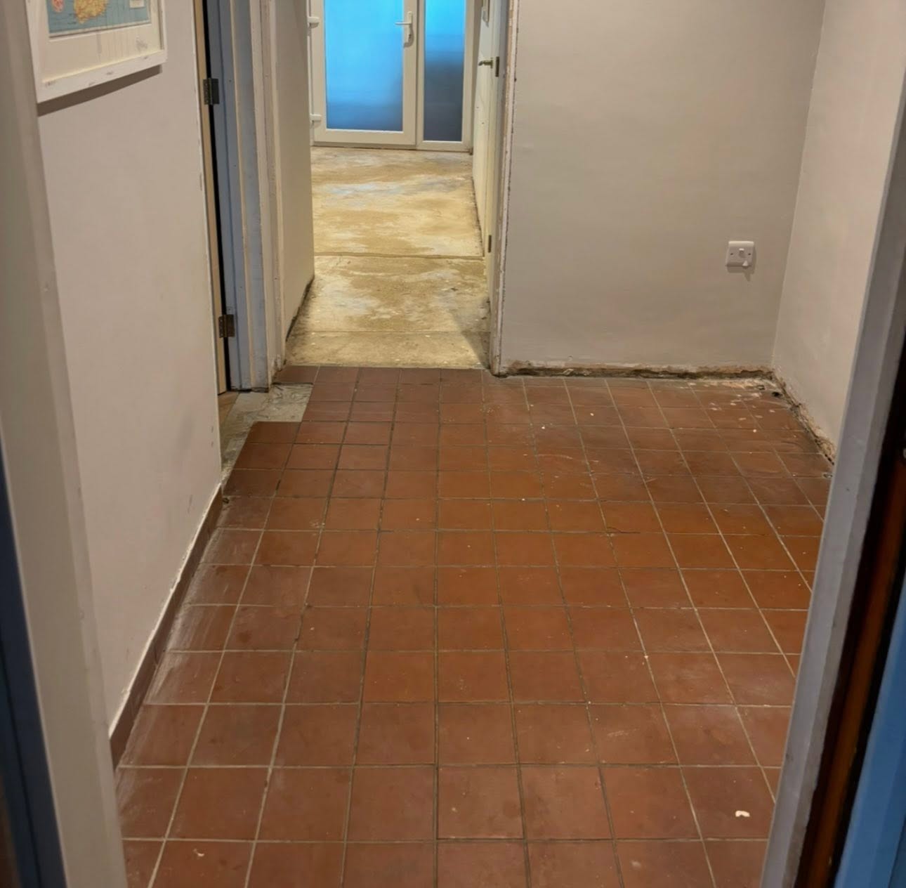 Old worn red quarry-tiled hallway floor before retiling