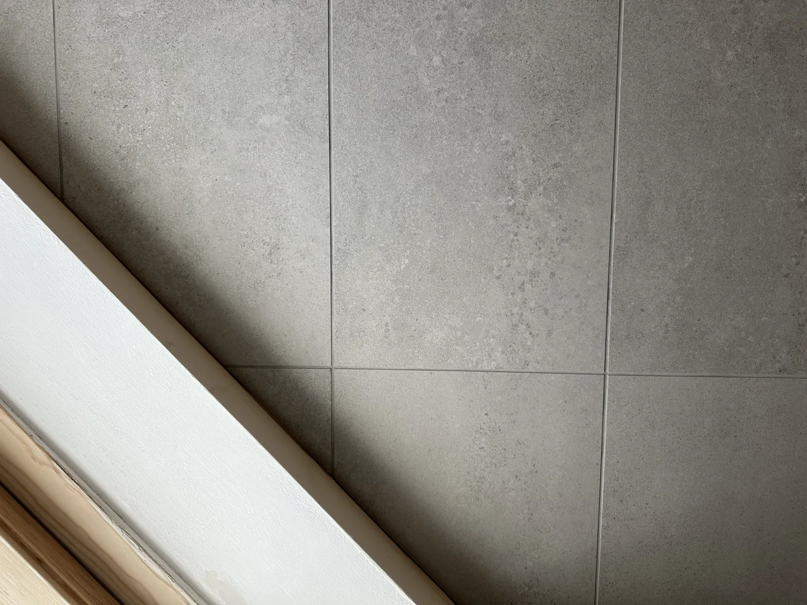 Grey tiled shower enclosure with recessed storage niche