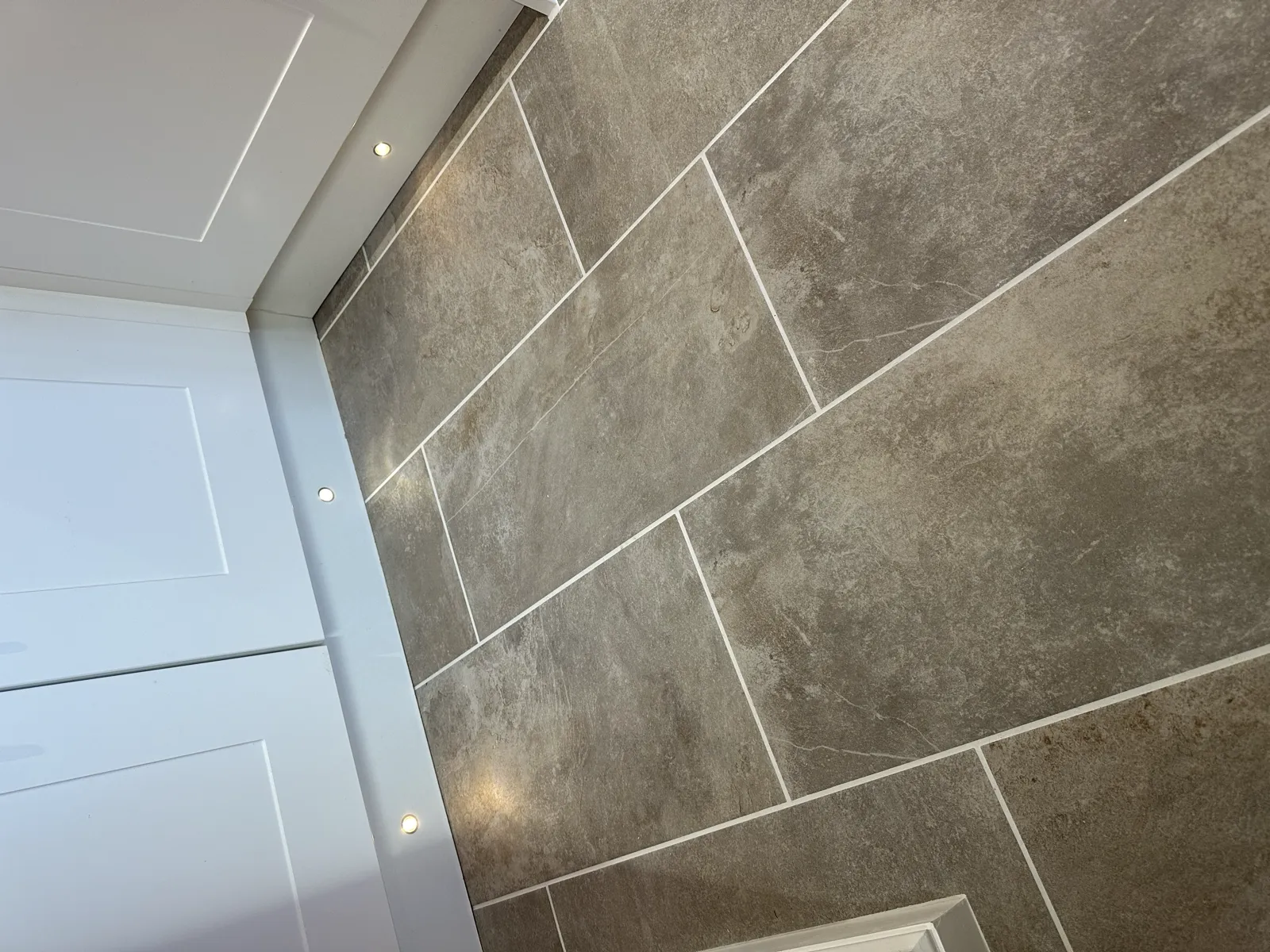 Grey marble-effect tiled bath surround