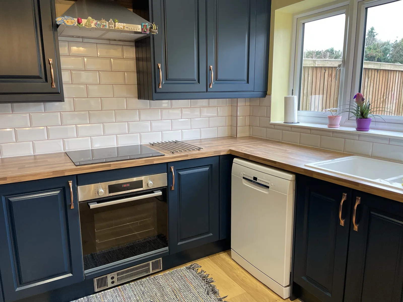 Navy shaker kitchen with cream metro tile splashback and wood worktop